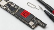 Системная плата iPhone с процессором A13 и красной предупреждающей наклейкой на антистатическом коврике