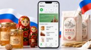 Смартфон с приложением WeChat, российские товары: мед, мука и матрешки на светлом фоне