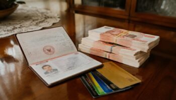 Паспорт, банковские карты и пачки денег на старом полированном столе