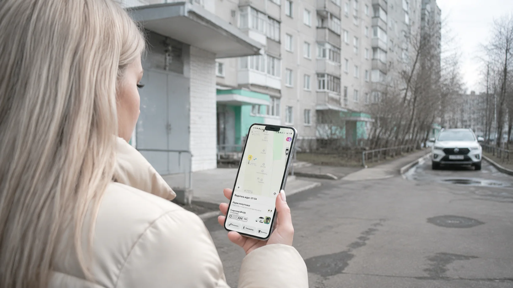 Девушка смотрит в приложение такси